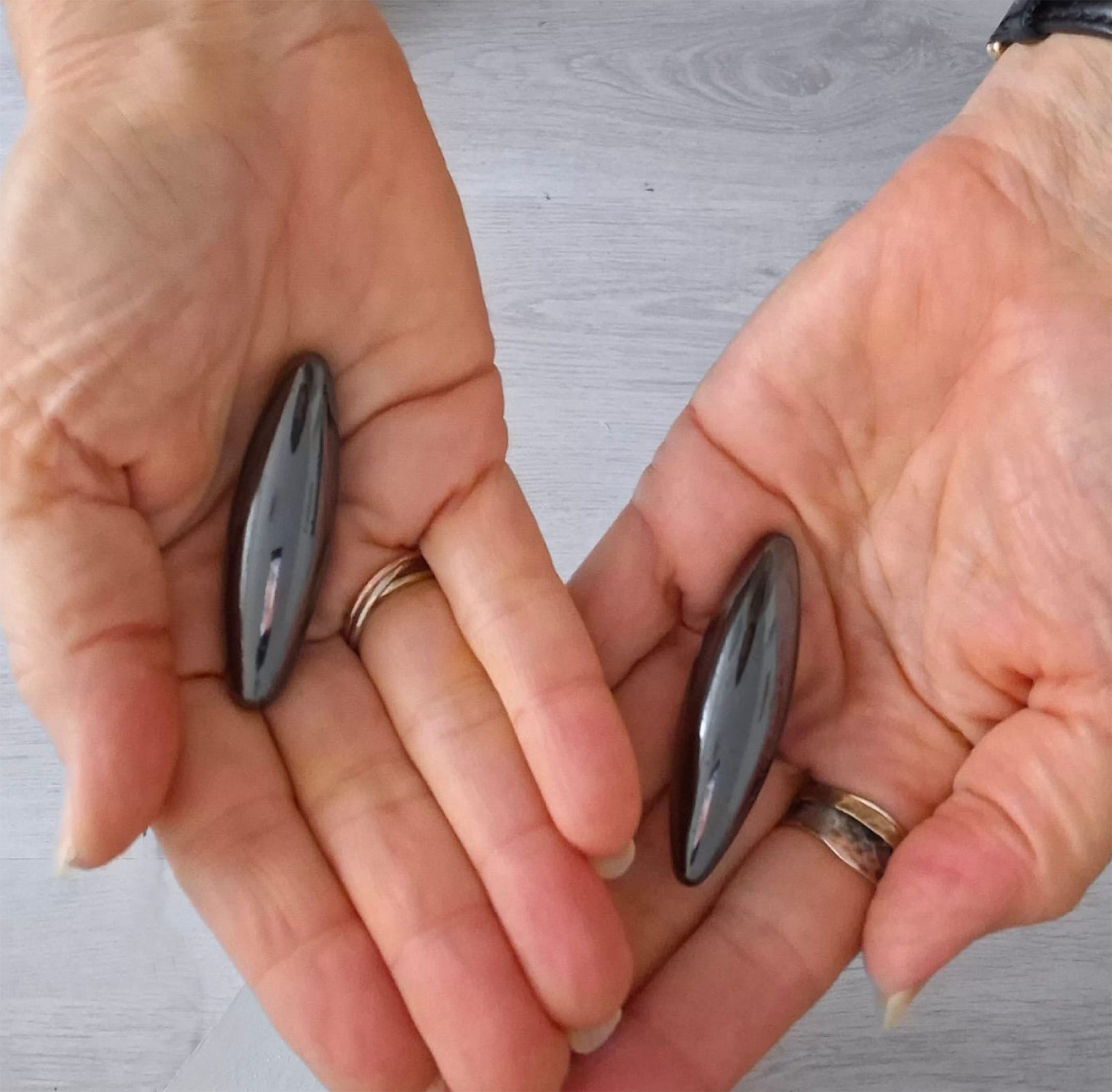 Magneet Therapie 2 Magneet therapie set van Hematiet en Magnetiet in twee open handen, ter visualisatie van formaat en energetisch gebruik